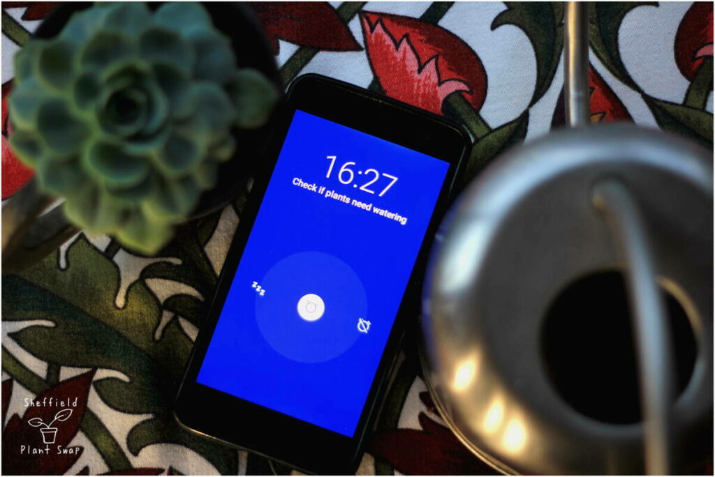 Mobile phone with alarm to remind you to check if you need to water your houseplant